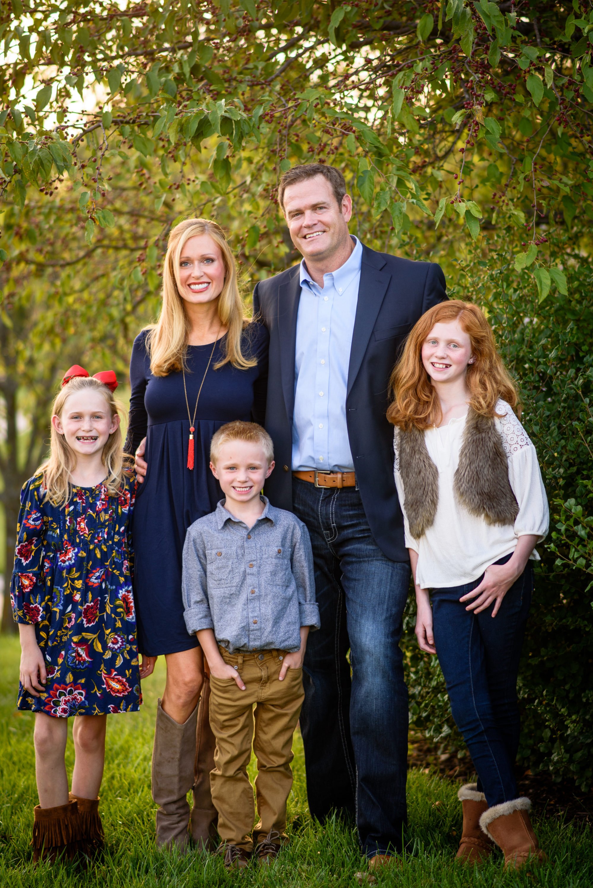 Dr. Ries' wife, two daughters and son standing outside in front of a tree.