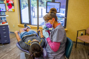An Orthodontist at Robinson + Ries providing orthodontic treatment to a young patient.