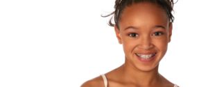 Children's Orthodontics by Robinson and Ries. Young girl with braces smiling in front of white background.