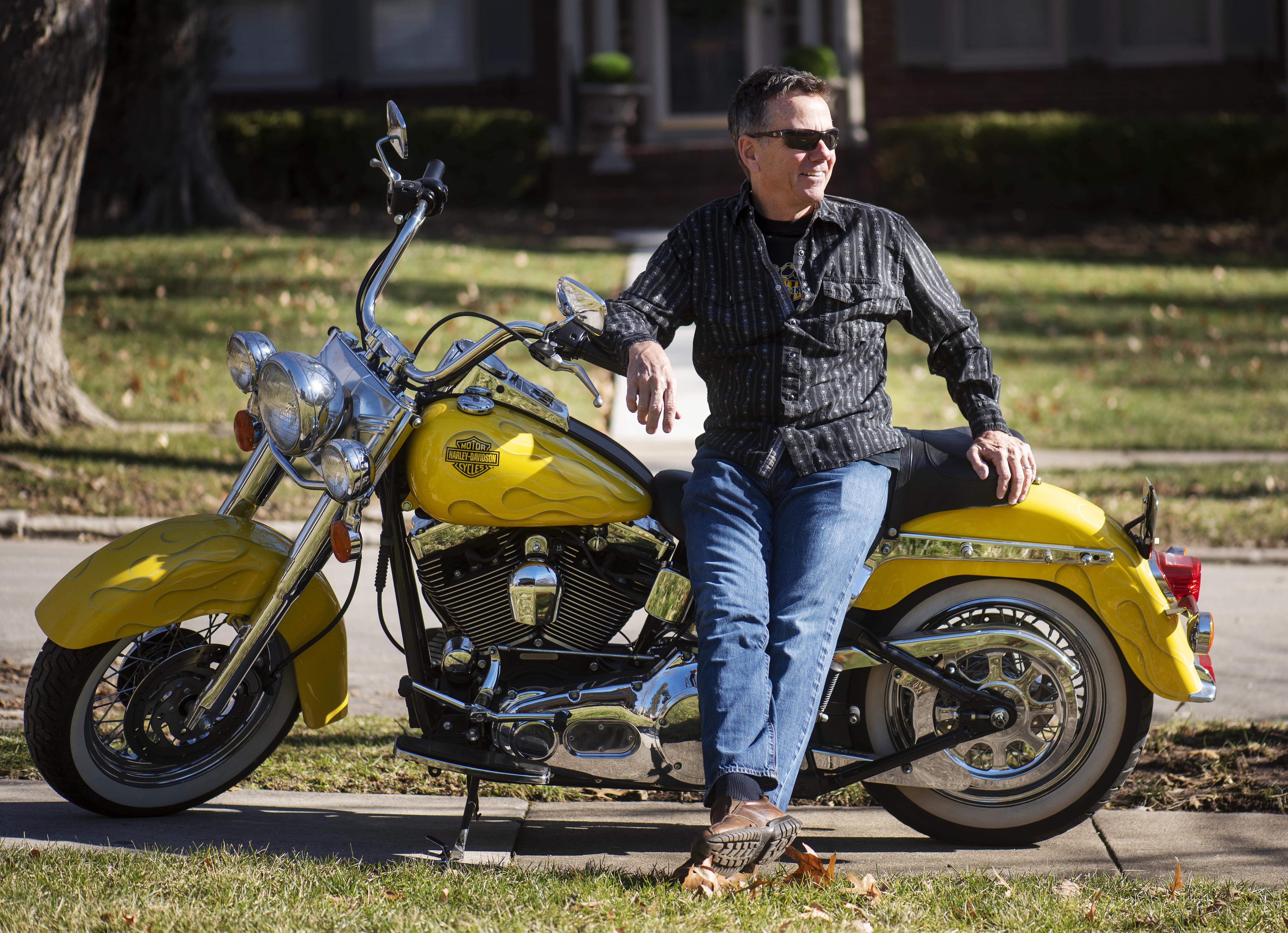 Orthodontist, Dr. Robinson sitting on a yellow motorcycle.